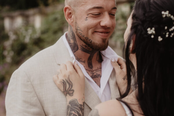 Bräutigam schaut lächelnd zur Braut im Schlosspark Altenstein