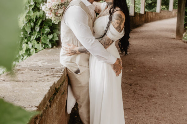 Brautpaar küsst sich unter einer Pergola im Schlosspark Altenstein