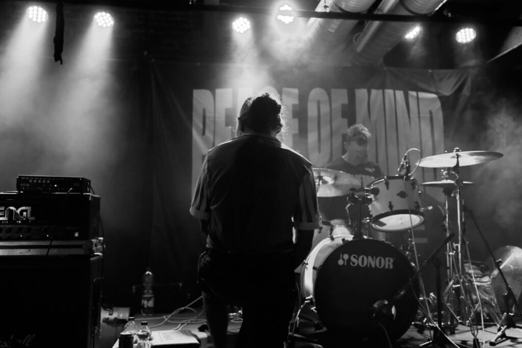 Band und Schlagzeug auf der Bühne in Schwarzweiß