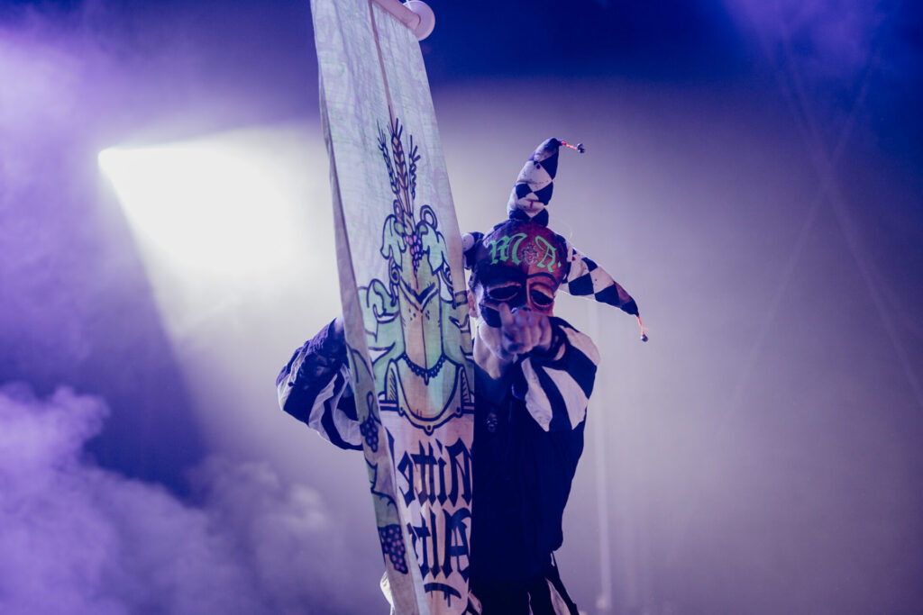 Sänger mit erhobenem Stoffbanner im Bühnenlicht beim NEXUS Festival