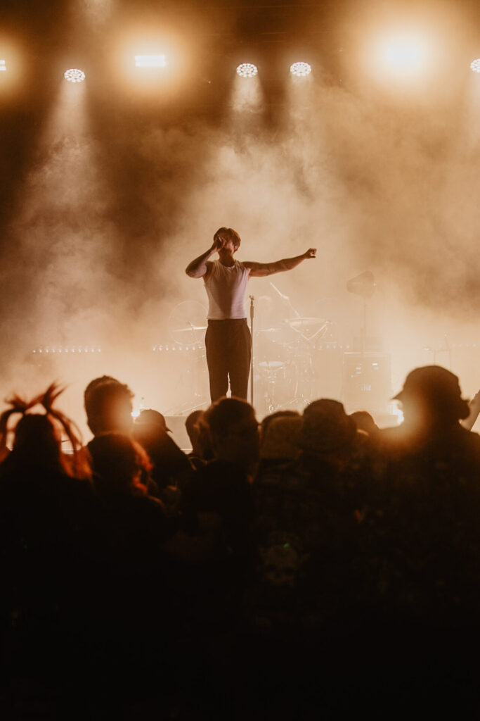 Silhouette eines Sängers vor Licht und Publikum beim NEXUS Festival