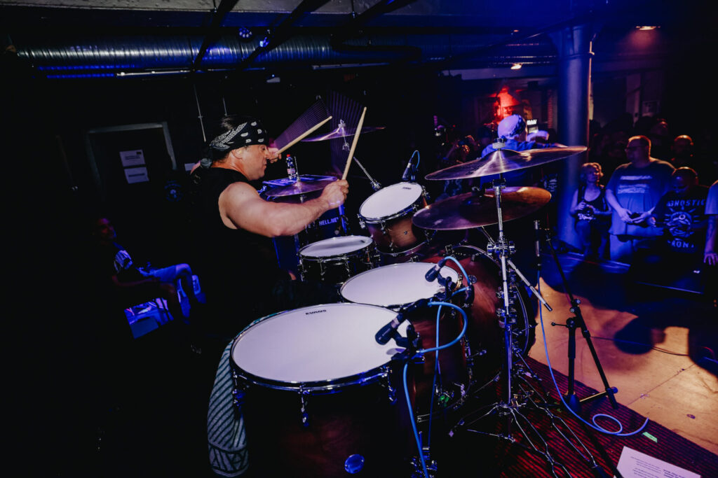 Schlagzeuger hinter dem Drumset in blauem Bühnenlicht